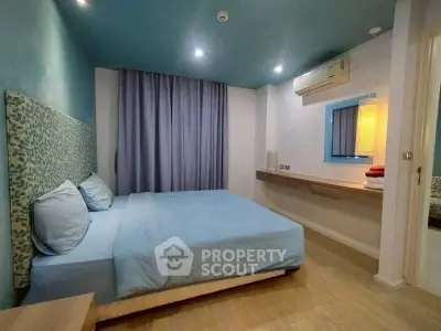 Modern bedroom with blue accents and air conditioning, featuring a cozy bed and stylish decor.