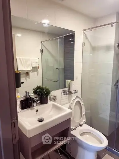 Modern bathroom with glass shower and sleek fixtures in a contemporary apartment.