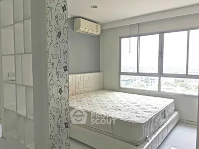 Bright bedroom with large window and air conditioning, featuring a comfortable mattress and stylish decor.