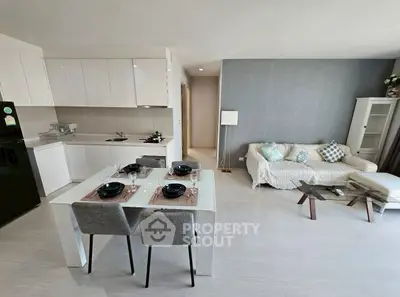 Modern open-plan living room and kitchen with stylish decor and dining area.