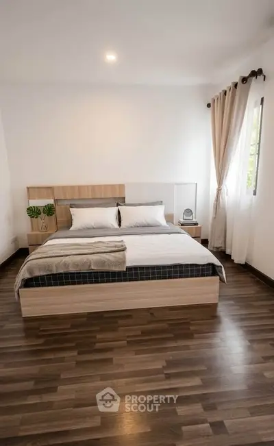 Modern bedroom with stylish wooden flooring and natural light
