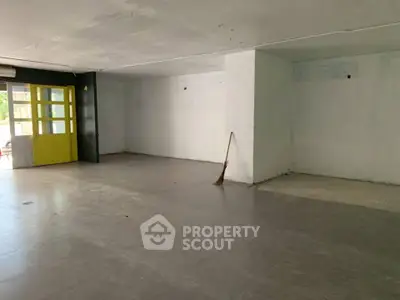 Spacious empty room with tiled flooring and large windows, ideal for customization.