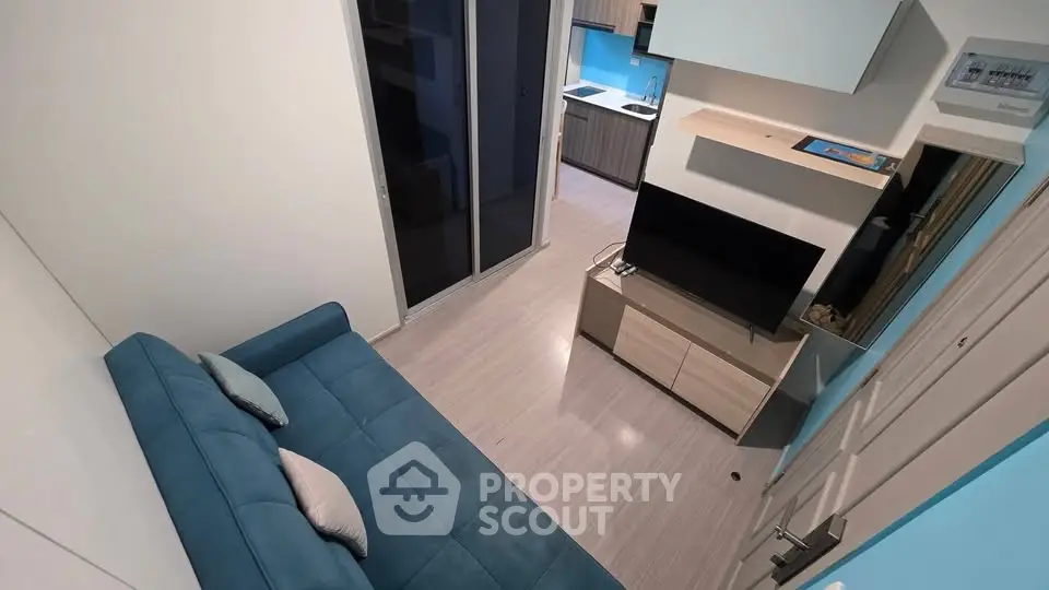 Modern compact living room with blue sofa and wall-mounted TV