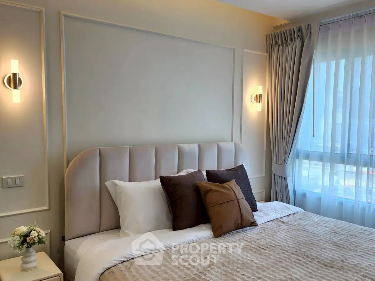 Luxurious bedroom with elegant decor and large window offering natural light.