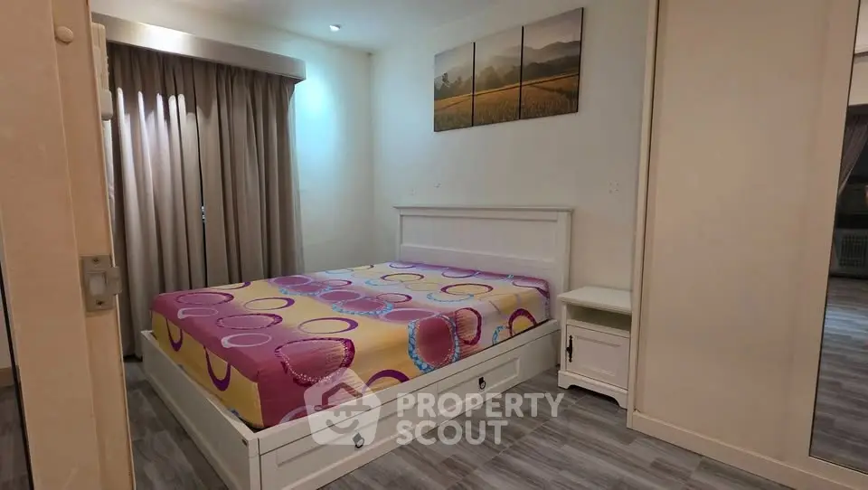 Cozy bedroom with modern decor and vibrant bedding in a stylish apartment.