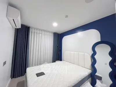 Modern bedroom with stylish blue and white decor, featuring a unique mirror and air conditioning.