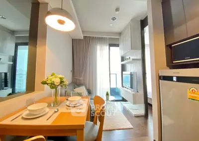 Modern open-plan living room with dining area, stylish decor, and natural light.