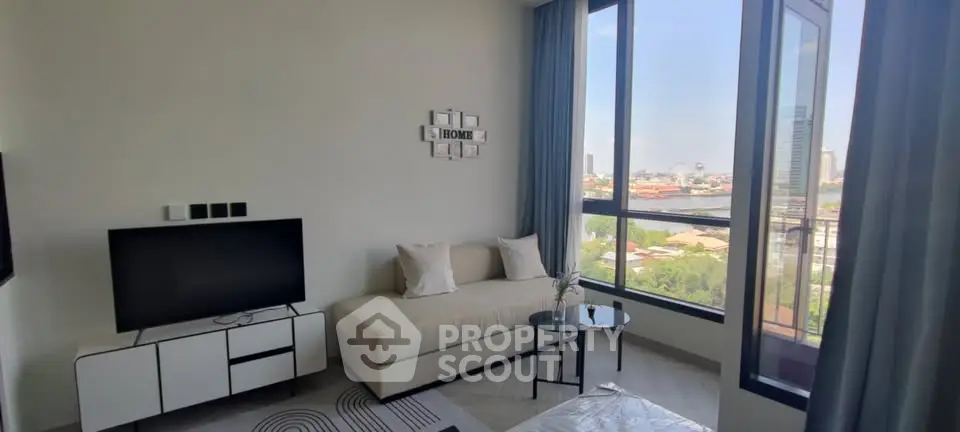 Modern living room with large windows and city view, featuring a cozy sofa and sleek TV stand.