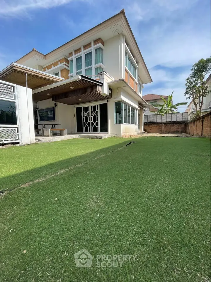 Spacious modern house with lush green lawn and stylish exterior design, perfect for family living.