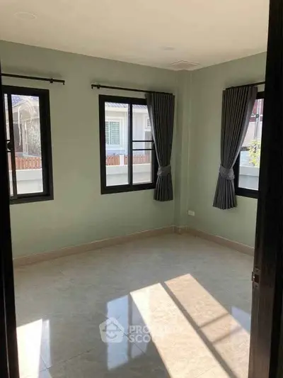 Spacious empty room with large windows and elegant curtains, perfect for customization.