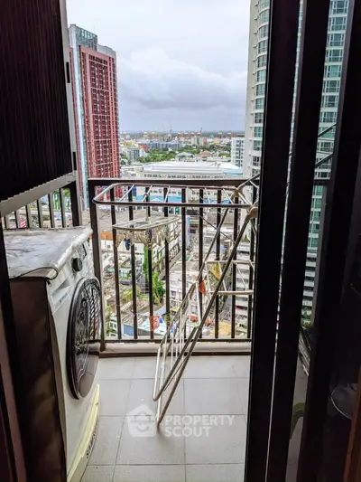 High-rise balcony with city view and washing machine, perfect for urban living.