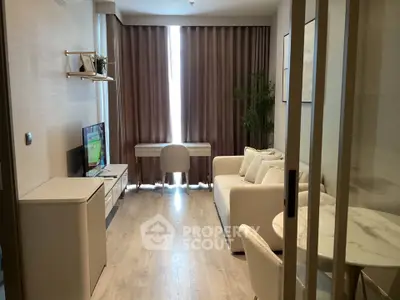 Modern living room with elegant decor and natural light, featuring a cozy sofa and a sleek TV setup.
