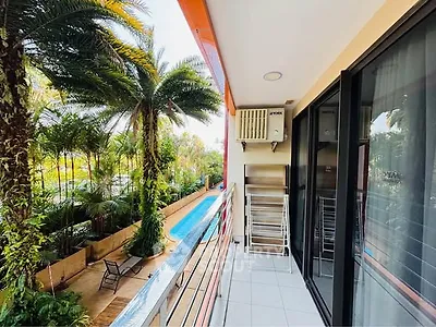 Charming balcony with pool view and lush greenery, perfect for relaxation and outdoor enjoyment.