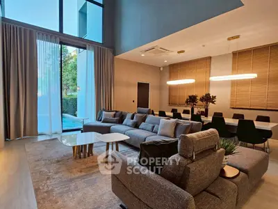 Luxurious modern living room with high ceilings and elegant dining area