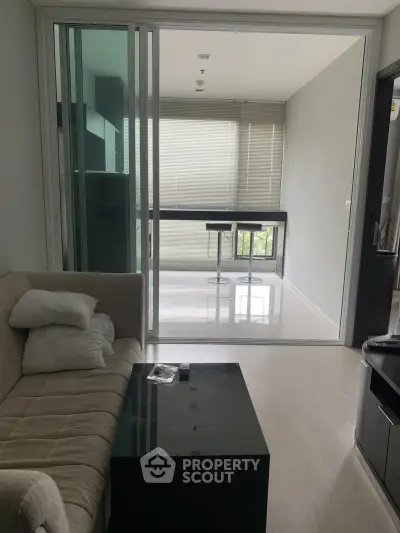 Modern living room with glass partition and sleek furniture in a stylish apartment.
