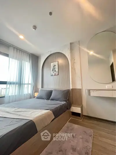 Modern bedroom with stylish decor and large window for natural light.