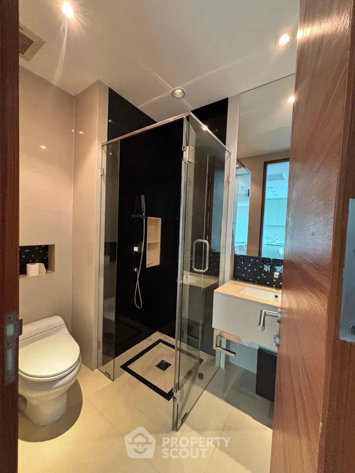 Modern bathroom with glass shower and sleek fixtures in a contemporary apartment.