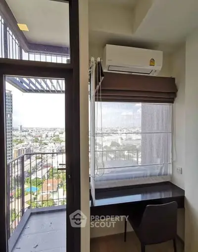 Modern study area with city view and balcony access in high-rise apartment