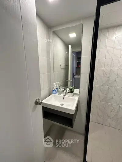 Modern bathroom with sleek sink and large mirror in compact space