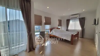 Spacious bedroom with large windows and modern decor in a bright apartment