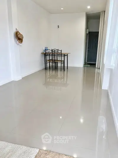 Spacious minimalist dining area with sleek tiled flooring and modern furniture