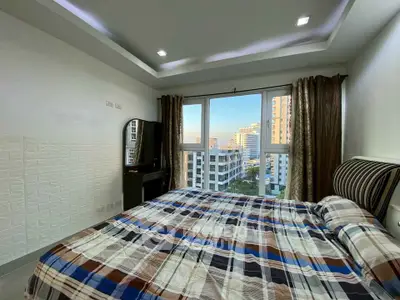 Modern bedroom with large window offering stunning city view in high-rise apartment