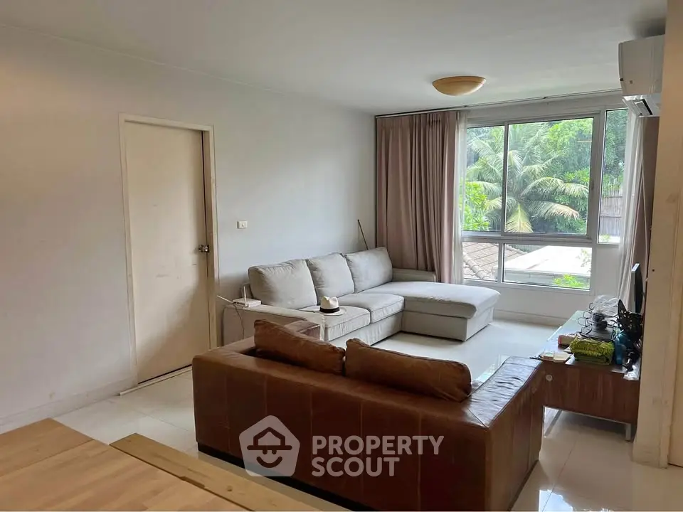 Spacious living room with modern furniture and large window view