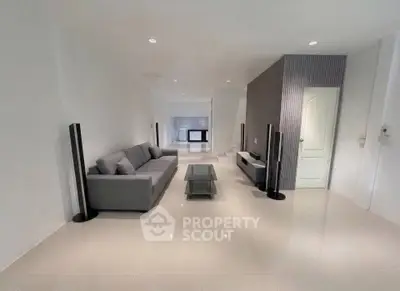 Spacious modern living room with sleek furniture and minimalist design.