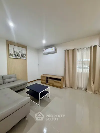 Modern living room with sleek furniture and air conditioning, perfect for relaxation.