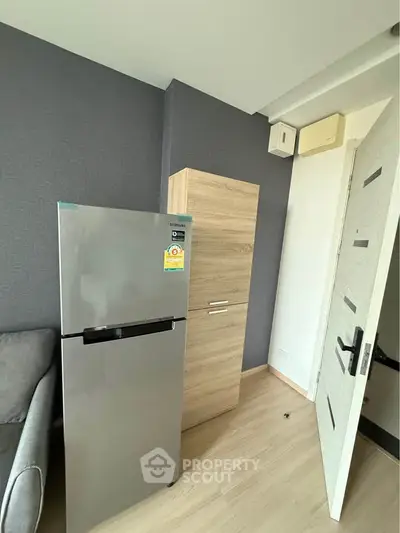 Modern apartment interior with sleek fridge and stylish storage cabinet