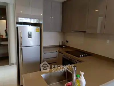 Modern kitchen with sleek cabinetry and stainless steel appliances in a contemporary apartment.