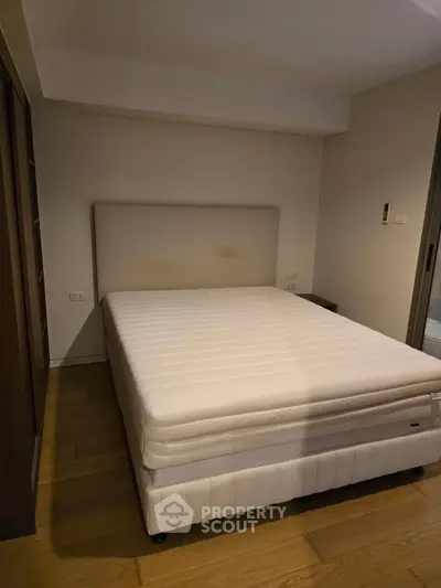 Cozy bedroom with a comfortable bed and wooden flooring, perfect for relaxation.