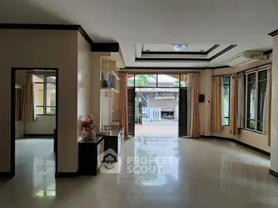 Spacious living room with large windows and garden view, perfect for family gatherings.