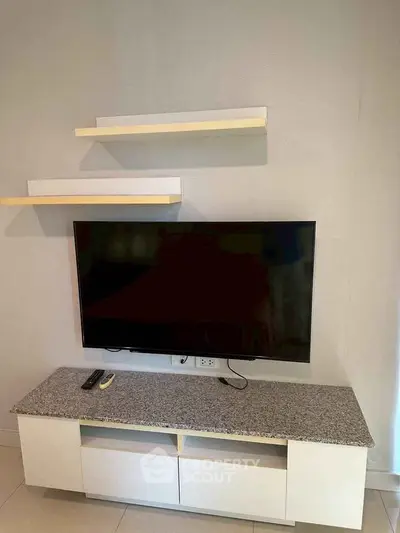 Modern living room with wall-mounted TV and sleek storage unit