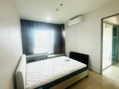 Modern bedroom with natural light, featuring a comfortable bed and air conditioning, ideal for relaxation.
