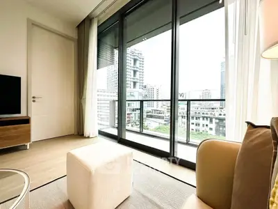 Modern living room with large windows and city view, featuring stylish furniture and natural light.