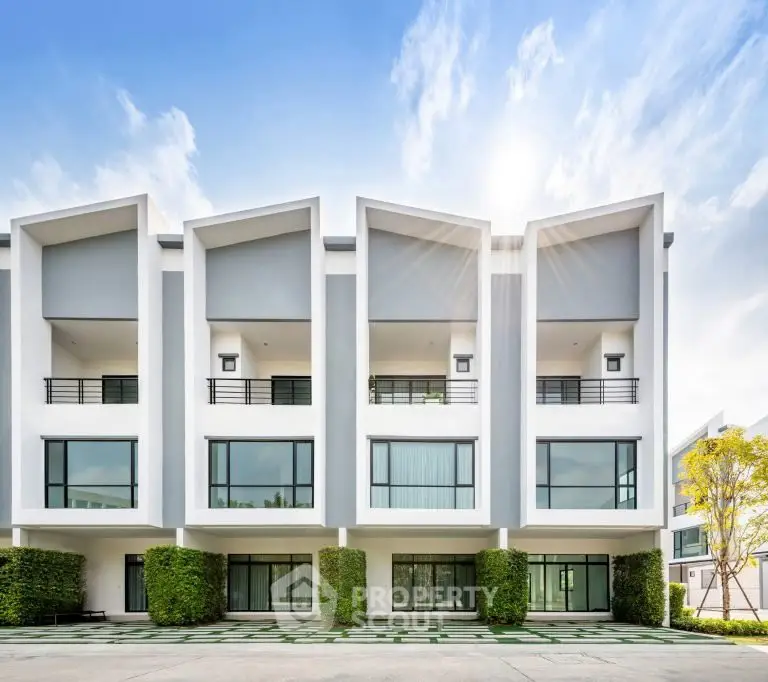 Modern townhouse exterior with unique architectural design and lush landscaping