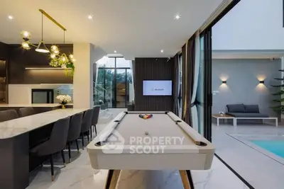 Luxurious modern living area with pool table and open view to outdoor pool