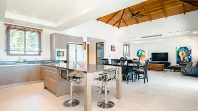 Spacious open-plan kitchen and living area with modern design and high ceilings.