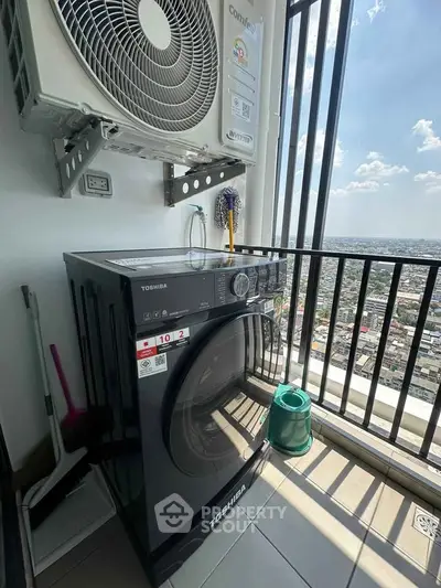 High-rise balcony with city view featuring modern washing machine and air conditioning unit.