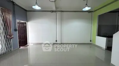 Spacious empty living room with tiled floor and open kitchen layout