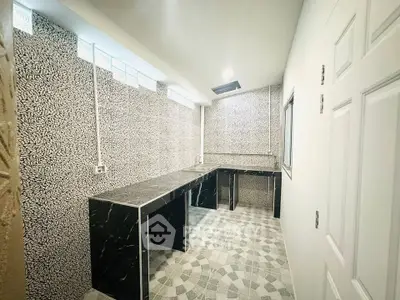 Modern kitchen with sleek black countertops and patterned tile flooring