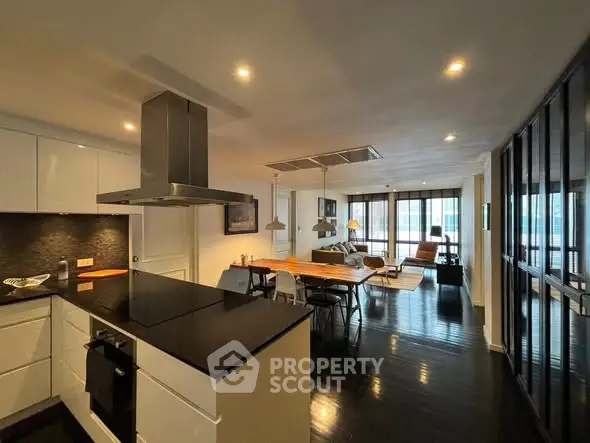 Modern open-layout kitchen and living room with sleek design and ample natural light.