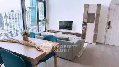 Modern living room with city view, stylish furniture, and large windows in a high-rise apartment.