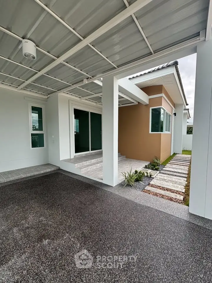 Modern house exterior with covered carport and landscaped walkway