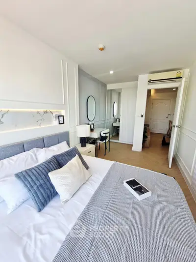 Modern bedroom with stylish decor and natural light, featuring a cozy bed and elegant furnishings.