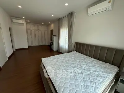 Spacious bedroom with modern design and ample natural light, featuring built-in wardrobes and air conditioning.