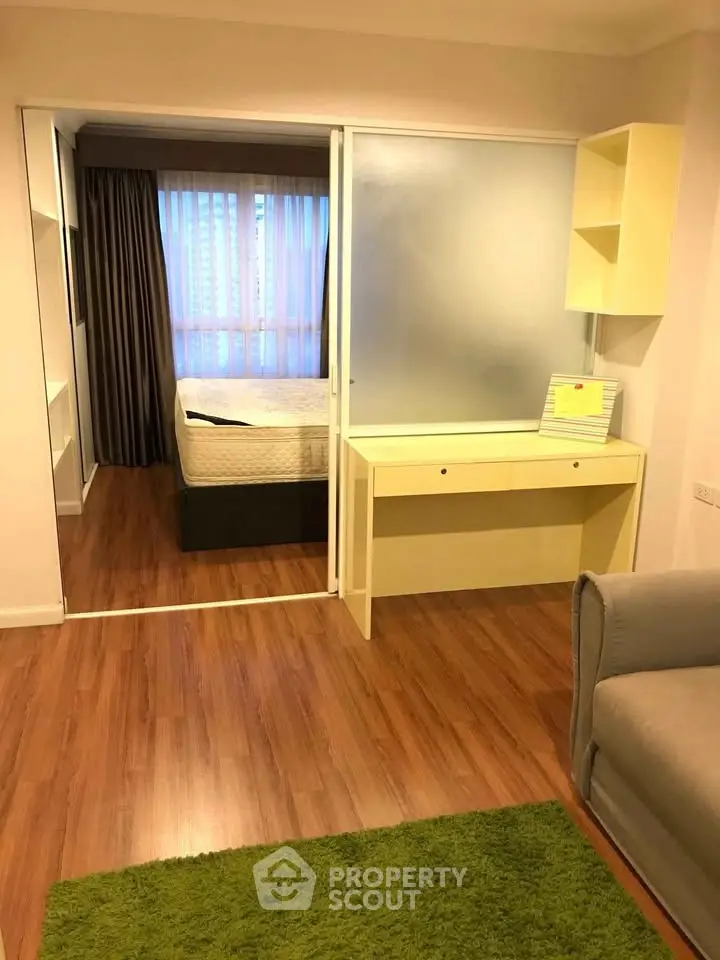 Cozy bedroom with wooden flooring and modern furnishings in a stylish apartment.