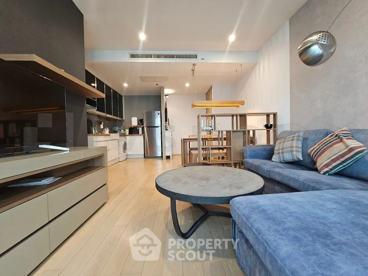 Modern open-plan living room with stylish furniture and sleek kitchen design