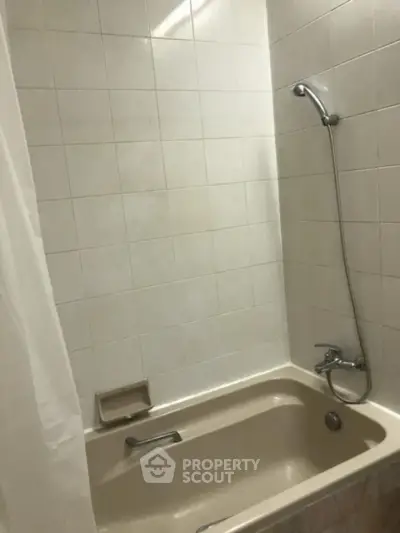 Cozy bathroom with classic bathtub and shower combo, perfect for relaxation.